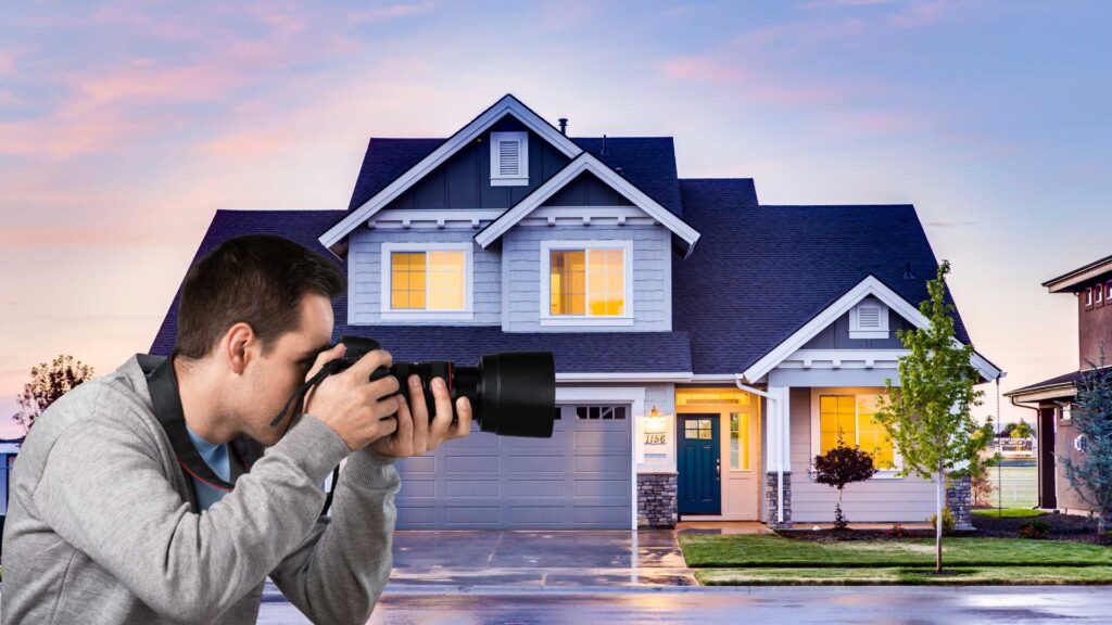 A real estate photographer infront of a house taking a picture